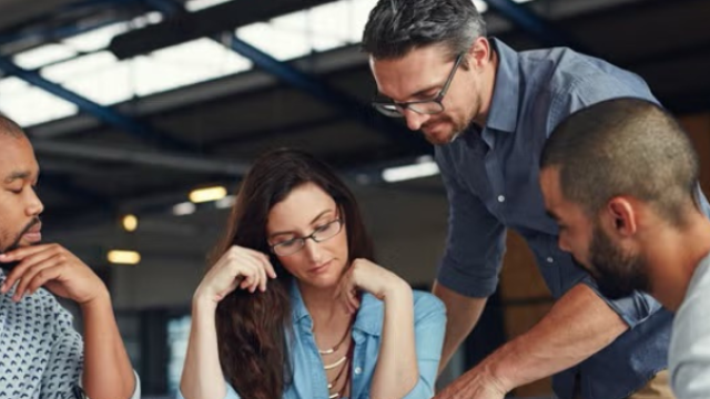 Co-workers reviewing a presentation demonstrating how a travel policy can set up your 2025 business travel up for success.
