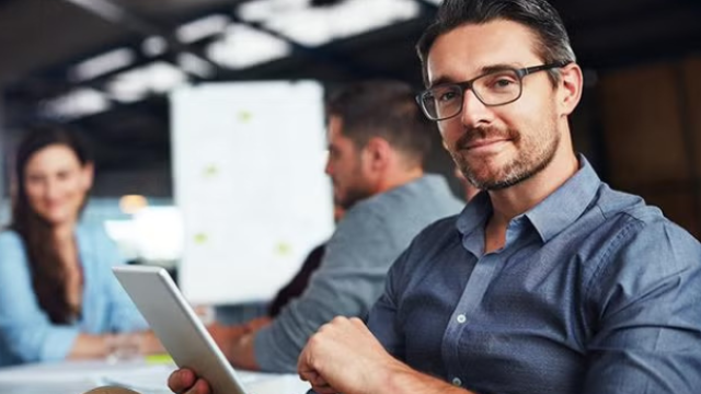 Man holding a tablet in the office how to leverage corporate travel discounts to maximise your savings.