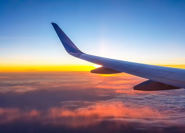 Plane flying over sunset