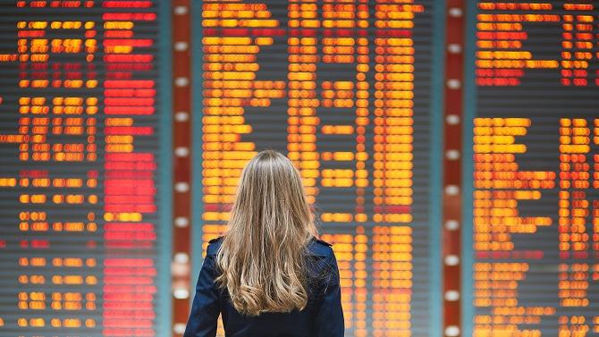 Lady looking at flight board at the airport