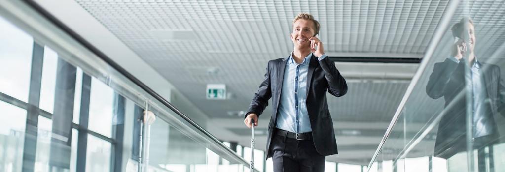 Male walking through airport on phone