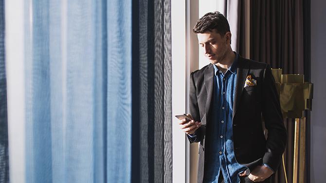 Man looking at phone in hotel room