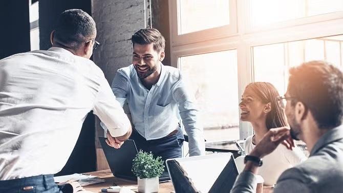 Co-workers shaking hands representing essential planning tips for business travel.