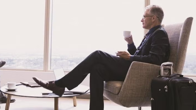 Man sitting in an airport lounge demonstrating how expert help can reduce the stress of business travel.