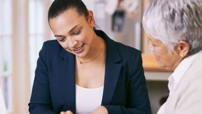 A travel professional advising an elderly woman representing smart ways to reduce business travel costs.