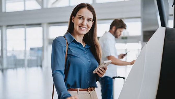 A woman standing at the check-in counter at the airport representing the State of the Market* Survey for Flight Centre Corporate has revealed that 40 per cent of businesses plan to increase their travel in FY25 (July to June).