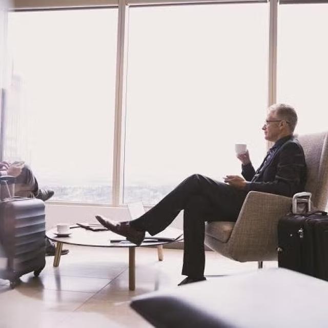 Man sitting in an airport lounge demonstrating how expert help can reduce the stress of business travel.