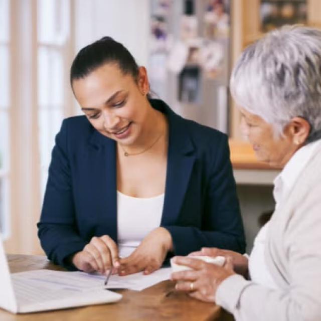 A travel professional advising an elderly woman representing smart ways to reduce business travel costs.